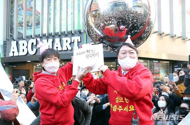 [부산=뉴시스] 하경민 기자 = 국민의힘 윤석열 대선 후보가 이준석 당 대표와 함께 4일 부산 부산진구 서면 일대에서 선거운동을 펼치던 중 '오늘부터 딱 95일! 단디 하자'라고 적힌 케익을 선물받고 있다. 2021.12.04. yulnetphoto@newsis.com