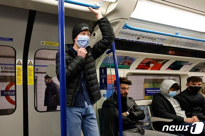 28일(현지시간) 신종 코로나바이러스 감염증 신종 변이 '오미크론' 확산 우려가 커지고 있는 가운데 영국 런던 지하철 안에서 마스크를 착용하지 않은 시민이 앉아있다. © AFP=뉴스1 © News1 윤지원 기자