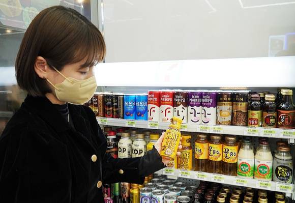 세븐일레븐에서 소비자가 온장음료를 고르고 있는 모습 [사진=세븐일레븐]