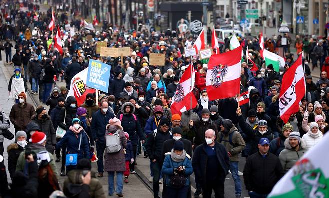 지난 4일(현지시간) 오스트리아 수도 빈에서 시위대가 국기와 각종 플래카드를 들고 코로나19 규제 조치와 백신 접종 의무화에 반대하며 가두행진을 벌이고 있다. 빈 | 로이터연합뉴스
