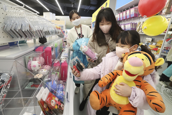 Customers pick up Disney goods at the KT M&S store in Times Square in Yeongdeungpo District, western Seoul on Tuesday. The KT subsidiary, which specializes in selling smartphones, has opened a Disney character shop within Times Square. The company signed an official licensing contract with The Walt Disney Company Korea to sell Disney character goods. [KT M&S]