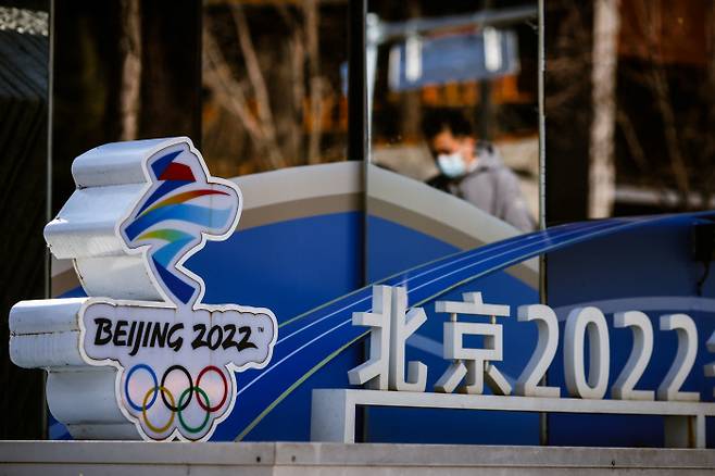 한 남성이 2개월여 앞으로 다가온 2022 베이징 동계 올림픽 로고 옆으로 지나가고 있다. 베이징ㅣ로이터 연합뉴스