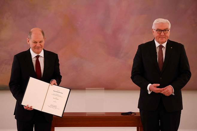 8일(현지시각) 독일의 새 총리로 선출된 올라프 숄츠(왼쪽)가 베를린의 대통령궁에서 프랑크-발터 슈타인마이어(오른쪽) 대통령으로부터 받은 임명장을 들어보이고 있다. /연합