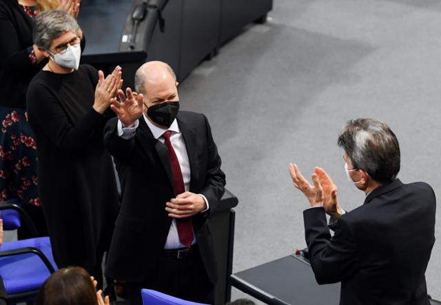 독일 사회민주당 소속 올라프 숄츠(가운데 총리 후보가 8일 베를린 연방하원에서 새 총리로 선출된 뒤 의원들의 축하 박수를 받고 있다. 베를린=로이터 연합뉴스
