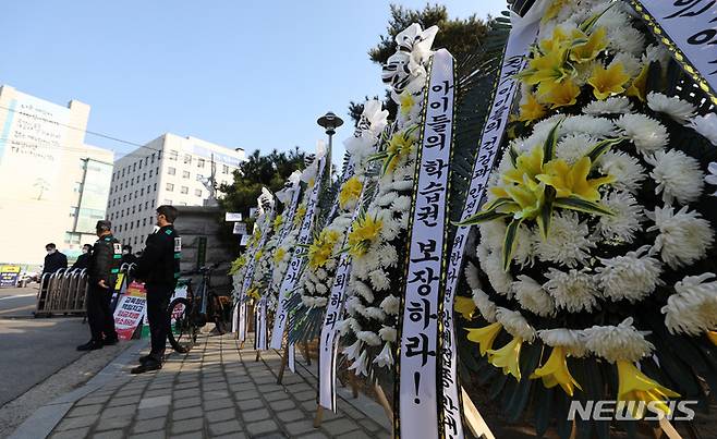 [서울=뉴시스] 이영환 기자 = 지난 7일 오전 서울 종로구 서울시교육청 앞에 청소년 방역패스를 규탄하는 근조화환이 설치되고 있다. 2021.12.07. 20hwan@newsis.com