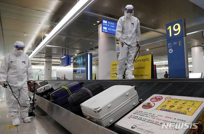 [인천공항=뉴시스] 고승민 기자 = 코로나19 오미크론 변이 바이러스 유입으로 방역에 비상이 걸린 3일 인천국제공항 제1터미널 세관구역 수하물 컨베이어 벨트에서 공항 관계자들이 방역을 하고 있다. 2021.12.03. kkssmm99@newsis.com