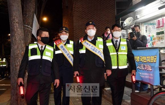 오늘은 방범대원 - 윤석열(오른쪽 두 번째) 국민의힘 대선후보와 이준석(세 번째) 대표가 7일 저녁 서울 마포구 합정동 홍익자율방범대를 찾아 방범대원들과 주택가 및 상가지역을 순찰하고 있다.정연호 기자 tpgod@seoul.co.kr