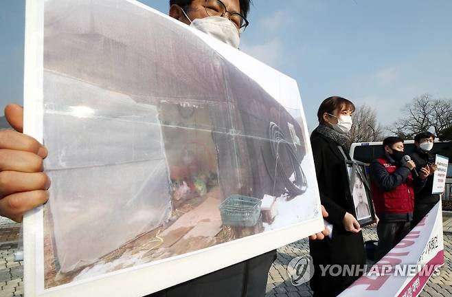 '비닐하우스는 집이 아니다' 지난달 12월 28일 오후 청와대 분수대 앞에서 열린 '이주노동자 비닐하우스 숙소 산재사망 진상 규명 및 대책 마련 촉구 기자회견'에서 참석자가 앞서 사망한 캄보디아 출신 여성노동자의 숙소 사진을 들고 있다. [연합뉴스 자료사진]