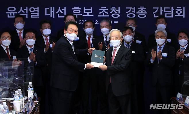 [서울=뉴시스] 국회사진기자단 = 윤석열 국민의힘 대선 후보가 9일 서울 마포구 경총회관에서 열린 한국경영자총협회 간담회에서 손경식 회장으로부터 기업들의 의견을 수렴한 경영계 건의서를 받고 있다. 2021.12.09. photo@newsis.com