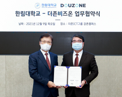 김용우(오른쪽) 더존ICT그룹 회장과 최양희 한림대 총장이 업무협약서를 교환하고 있다. 더존비즈온 제공