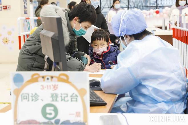[베이징=신화/뉴시스] 중국 수도 베이징에 있는 코로나19 백신 접종센터에서 9일 3~11세 어린이들이 백신을 맞기 위해 등록을 하고 있다. 2021.12.12