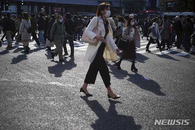 [도쿄=AP/뉴시스] 10일 일본 도쿄의 시부야 쇼핑가에서 마스크를 쓴 시민들이 교차로를 건너고 있다. 2021.12.10.