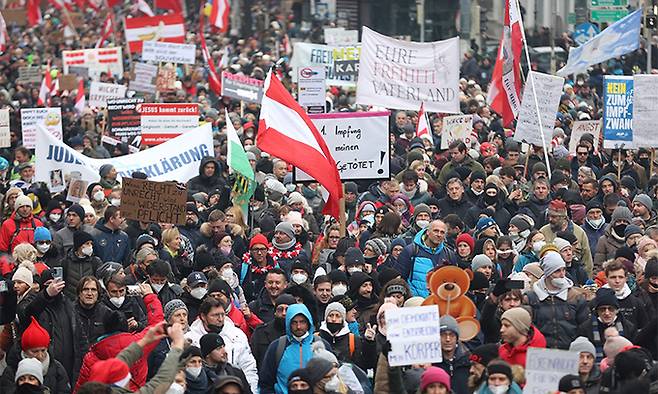 오스트리아가 신종 코로나바이러스 감염증(코로나19) 오미크론 변이 확산으로 비상인 가운데 11일(현지시간) 수도 빈에서 시위대가 플래카드와 깃발 등을 들고 코로나19 방역 조치에 항의하는 시위를 벌이고 있다. 빈=AFP연합뉴스