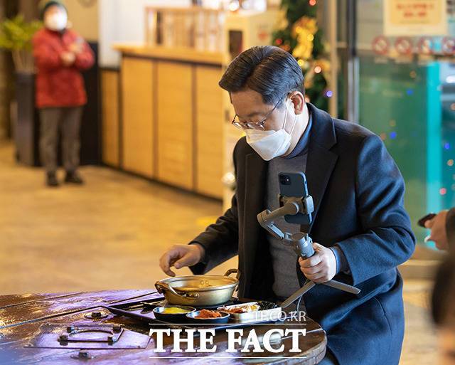 이재명 더불어민주당 대선 후보가 13일 오후 경상북도 군위군 군위영천휴게소 영천방향을 찾아 실시간 라이브 방송 '나홀로 한끼'를 진행하며 주문한 음식을 바라보고 있다. /이재명 캠프 제공