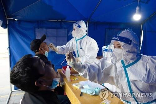 29일 중국 간쑤성의 코로나19 진료소에서 의료진이 검사를 진행하는 모습. AFP=연합뉴스