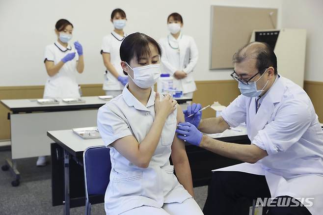 [도쿄=AP/뉴시스]지난1일 일본 도쿄에서 한 의료진이 코로나19 화이자 백신을 접종받고 있다. 일본에서는 이날부터 부스터샷 접종이 시작됐다. 2021.12.10