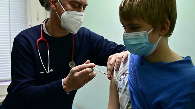독일 소아과 전문의 야코프 마스케 박사가 현지시간 14일 베를린에 있는 진료실에서 11세 소년에게 백신 접종을 하고 있는 모습.(사진=AFP 연합뉴스)