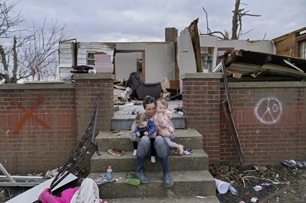 토네이도로 집 절반이 날아간 미국 켄터키주 도슨 스프링스시 자택 앞에서 한 어머니가 아이들을 안고 있다./AP연합뉴스