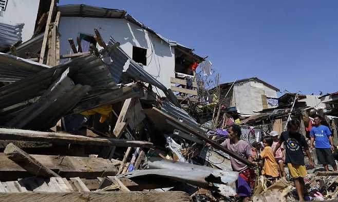 태풍 라이의 영향으로 부서진 가옥에서 생필품을 되찾기 위해 애쓰는 피해 주민들의 모습.(사진=AP 연합뉴스)