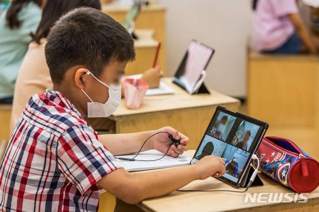 [서울=뉴시스] 사진공동취재단 = 학교 원격수업에서 쓰이는 태블릿PC 등 디지털기기 활용법은 적어도 초등학교 5학년이 지나야 가르치는 게 좋다는 교육 전문가와 시민들의 공론화 결과가 나왔다.. 사진은 지난 7월 서울 성동구 무학초등학교 긴급돌봄교실에서 2학년 학생들이 태블릿PC를 써서 온라인 수업을 진행하는 모습. 2021.07.14. photo@newsis.com