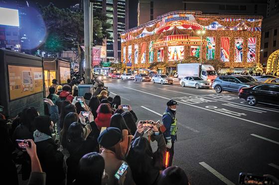 22일 오후 서울 신세계백화점 본점 맞은편 보도가 미디어 파사드를 보려는 시민들로 북적이고 있다. 전민규 기자