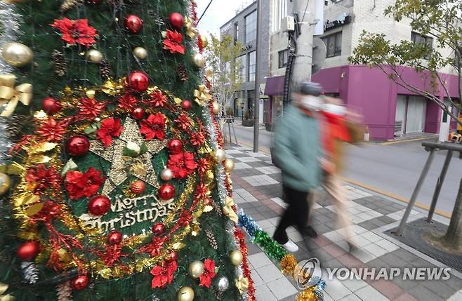 크리스마스 트리 장식된 광주 양림동 (광주=연합뉴스) 천정인 기자 = 성탄절인 25일 광주 남구 양림동에서 시민들이 크리스마스 장식 사이를 걸어가고 있다. 2021.12.25 iny@yna.co.kr