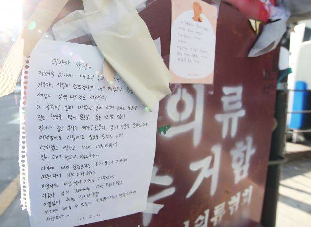 지난 19일 영아가 숨진 채 발견된 경기도 오산시의 한 의류수거함에 27일 오전 추모 메시지와 물품이 놓여 있다. 경기 오산경찰서는 자신이 출산한 아기를 의류 수거함에 유기한 혐의(사체 유기 등)로 A(20대)씨를 붙잡아 지난 26일 구속했다. 연합뉴스