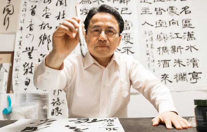 소순만 서훈팀장이 28일 오후 서울 자택에서 붓을 들어 보이고 있다. 소 팀장은 26년간 5명의 대통령이 수여한 훈장 증서를 직접 붓글씨로 써왔다. “종이에 붓글씨로 남긴 진심이 전달되기 바란다”고 했다. /김지호 기자