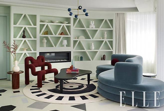 오울 디자인이 자체 제작한 곡선 소파는 모헤어 벨벳 덮개를 씌웠다. 거실 중앙에 놓인 커피 테이블은 크리스 마틴이 디자인한 ‘퍼들(Puddle)’. 강렬한 빨간색이 돋보이는 의자는 1984년에 테르에 에크스트룀(Terje Ekstrøm)이 제작한 ‘엑스트렘(Ekstrem)’ 체어. 붉은 사이드 테이블은 콘란 숍의 대니얼 스코필드가 디자인한 ‘톨 매그(Tall Mag)’. 러그는 대니얼 스코필드가 제작한 마망 러그의 ‘리스(Reese)’다.