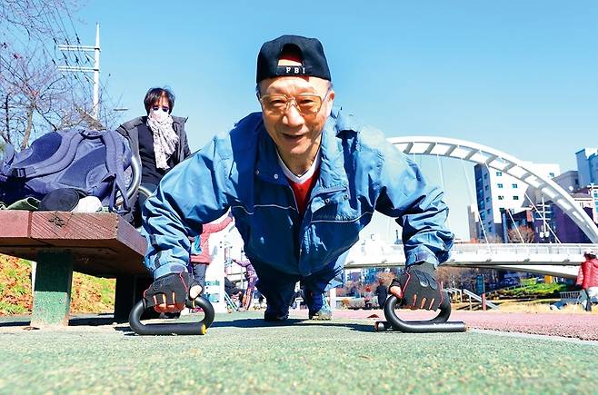 강철진씨는 건강관리 전도사를 자처하며 신중년을 대상으로 ‘50대 이후 체형관리 전략’을 강의하고 정기적으로 운동 동영상을 유튜브에 올리고 있다. 그는 ‘운동은 일상생활 속 습관이 돼야 한다’고 강조했다. 사진은 12월3일 오전 은평구 불광천변 운동시설에서 푸시업을 하는 모습. 손목에 부담을 덜어주고 바른 자세로 운동 효과를 높이기 위해 푸시업바를 활용한다. 정용일 선임기자 yongil@hani.co.kr