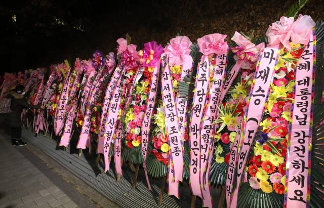 30일 밤 서울 강남구 일원동 삼성서울병원 앞에 박근혜 전 대통령 지지자들이 보낸 박 전 대통령 쾌유 기원 화환이 놓여 있다. /연합뉴스
