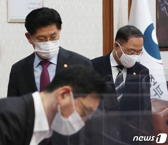 홍남기 경제부총리 겸 기획재정부 장관과 노형욱 국토교통부 장관이 23일 서울 종로구 정부서울청사에서 세종-서울 영상으로 열린 국무회의에서 국기에 경례를 마치고 착석 하고 있다. 2021.11.23/뉴스1 © News1 송원영 기자