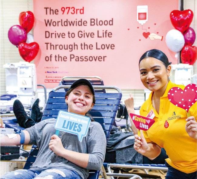 코로나19 발생 전 미국 맨해튼에서 개최된 제973차 유월절사랑 생명사랑 헌혈릴레이. 하나님의 교회 성도들이 채혈 중 환하게 웃고 있다.