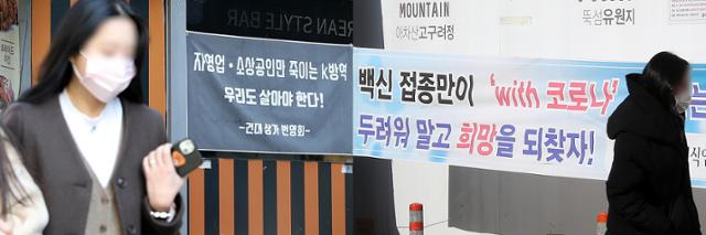 방역패스 찬반 논란이 한창인 6일 오후 서울 광진구 건대입구역 인근에 백신 접종과 방역 조치에 대한 상반된 의견을 적은 현수막이 걸려 있다. 뉴시스