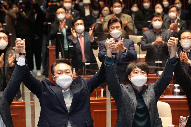 국민의힘 윤석열 대선 후보와 이준석 대표가 6일 저녁 국회에서 열린 의원총회에서 손을 맞잡고 있다. 국회사진기자단