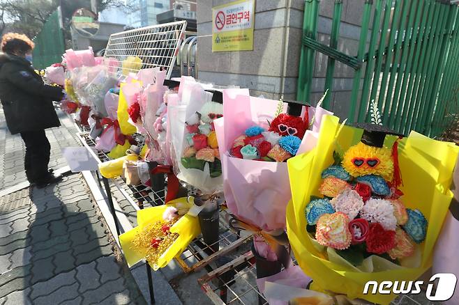 6일 졸업식이 열린 대구의 한 중학교 교문 앞에서 꽃을 파는 노점상이 꽃다발을 진열하고 있다. 2022.1.6/뉴스1 © News1 공정식 기자