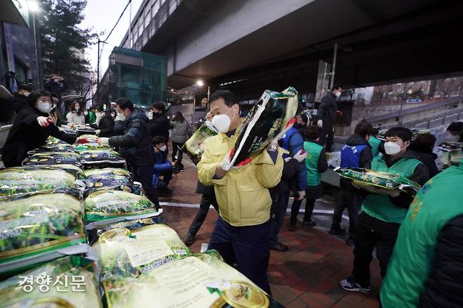 12년 째 신분을 밝히지 않고 매년 20kg 쌀 300포대를 전하는 기부자가 7일 새벽 성북구 월곡2동 주민센터 앞으로 쌀을 보냈다. 이승로 성북구청장(가운데)와 주민센터직원, 주민 등 30여 명이 이날 전달된 함께 쌀을 트럭에서 내리고 있다. | 성북구 제공