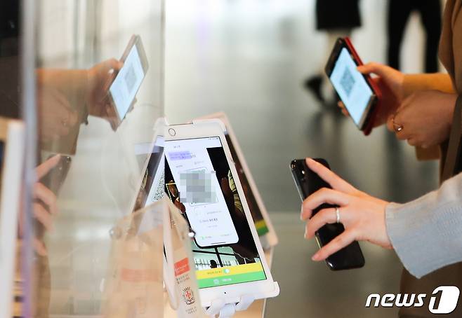 '방역패스(접종증명·PCR음성확인)'에 백신 유효기간을 적용한 첫날인 3일 서울 종로구 국립현대미술관에서 관람객들이 큐알(QR) 코드 스캔과 방역패스 유효 상태를 체크하고 있다. 2022.1.3/뉴스1 © News1 허경 기자