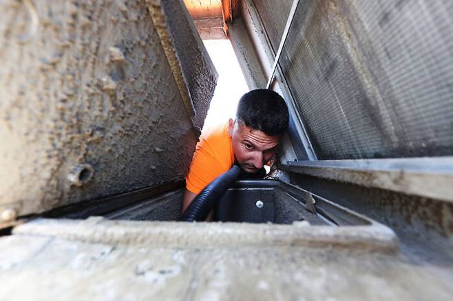 (사진) 2020년 8월 뉴욕주의 한 헬스클럽에서 에어컨으로 바이러스가 유입되는 것을 걸러내는 HVAC필터를 설치하기 위해 환기 덕트를 청소하는 모습. 게티이미지코리아.