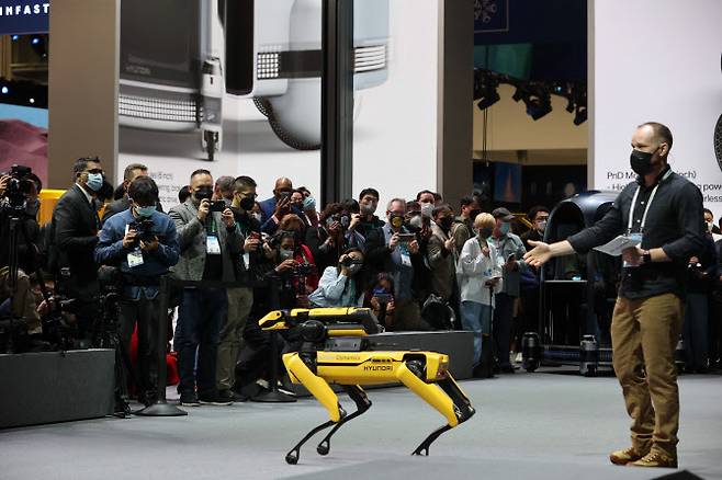 세계 최대 전자·가전·정보기술(IT) 전시회인 CES 2022가 개막한 5일(현지시간) 미국 네바다주 라스베이거스 컨벤션센터에 마련된 현대자동차 부스에서 관람객들이 4족 보행 로봇 ‘스팟’의 공연을 지켜보고 있다. (사진=뉴스1)