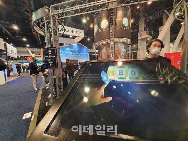 미국 라스베이거스 컨벤션센터 노스홀에 전시 부스를 꾸린 홀로인더스트리. 마사토시 이즈미 아스카넷 직원(오른쪽)이 기술을 설명하고 있다. (사진=김정유 기자)