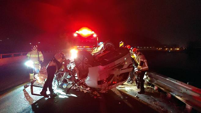 [철원=뉴시스] 김경목 기자 = 8일 오후 강원 철원소방서 119 구조대 대원들이 화천군 하남면 5번 국도에서 가드레일을 들이받고 전복된 QM6 SUV 차량에서 탑승자들을 구조하고 있다. 이 사고로 육군 부사관 등 3명이 숨지고 1명이 크게 다쳤다. (사진=강원도소방본부 제공) 2022.01.09. photo@newsis.com *재판매 및 DB 금지