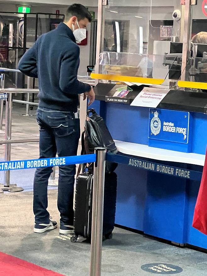 조코비치가 5일 밤 멜버른 국제공항에서 입국 심사를 받는 모습. 그는 코로나 백신 면제 사유를 서류로 입증 못했다는 이유로 비자가 취소돼 멜버른의 한 호텔에 억류돼 있었다./로이터 연합뉴스