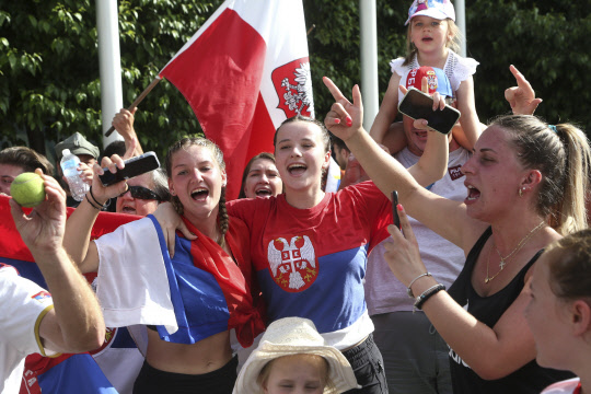 Fans of Serbia's Novak Djokovic react to news of his overturned ruling outside Federal Court ahead of the Australian Open in Melbourne, Australia, Monday, Jan. 10, 2022. An Australian judge has reinstated Djokovic's visa, which was canceled after his arrival last week because he is unvaccinated. (AP Photo/Hamish Blair)