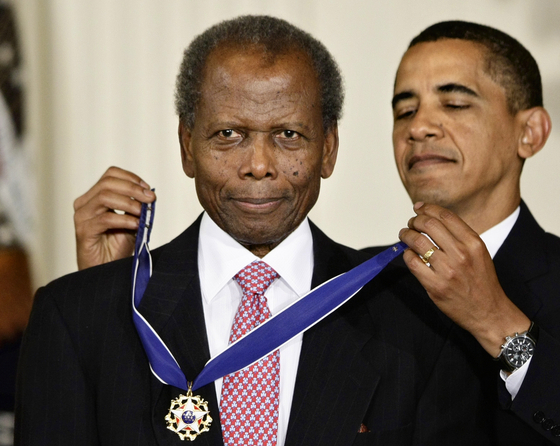 배우 시드니 포이티어가 2009년 백악관에서 버락 오바마 미국 전 대통령에게 자유 메달을 받던 모습이다. [AP=연합]