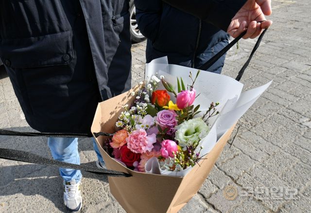 10일 서울 서초구 양재동 화훼공판장의 생화 꽃 도매시장에서 한 고객이 3만원에 산 꽃다발을 들어보이고 있다.