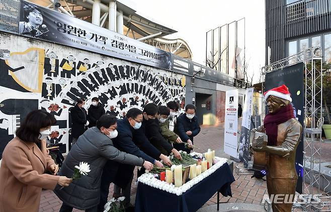 [대구=뉴시스] 이무열 기자 = '영원한 가객' 김광석 26주기 추모식이 열린 6일 오후 대구 중구 김광석 다시 그리기 길에서 참여자들이 헌화하고 있다. 2022.01.06. lmy@newsis.com