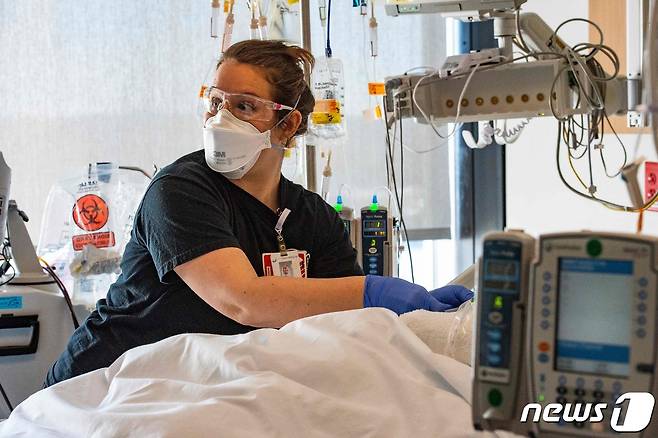 4일(현지시간) 미국 매사추세츠주 우스터 한 병원 중환자실에서 한 여성 의료인이 신종 코로나바이러스 감염증 환자를 돌보고 있다. 2022.01.04 © AFP=뉴스1