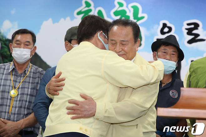 지난해 7월 30일 대구경북통합신공항 공동후보지인 군위군 소보면·의성군 비안면 유치 신청에 대한 극적인 합의가 이뤄진 가운데 권영진 대구시장과 김영만 군위군수가 군위군청 대회의실에서 결과 발표를 마친 뒤 포옹하고 있다. 2020.7.30/뉴스1 © News1 공정식 기자