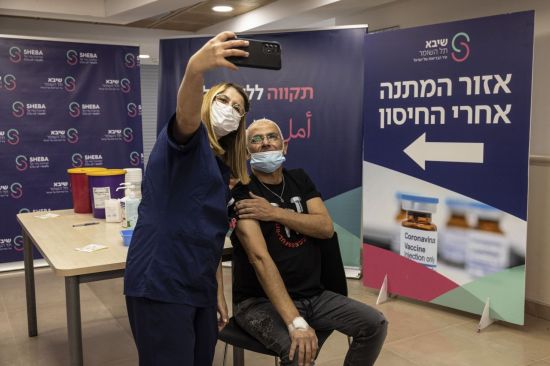지난달 31일(현지시간) 이스라엘 서부 라마트간의 셰바 메디컬 센터에서 샤론 타빕씨가 화이자 코로나19 백신 4차 접종을 하고 간호사와 함께 셀카를 찍고 있다. [이미지출처=AP연합뉴스]